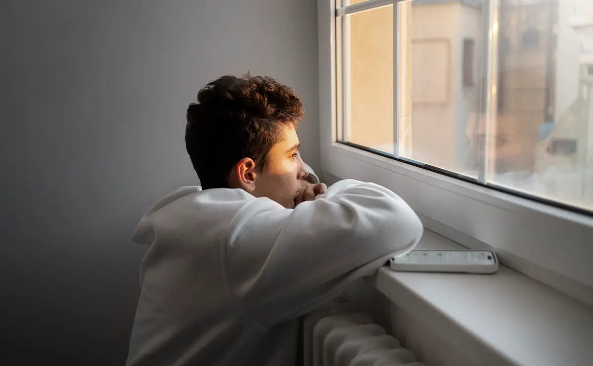 Persona reflexionando junto a una ventana sobre el miedo a la conexión emocional